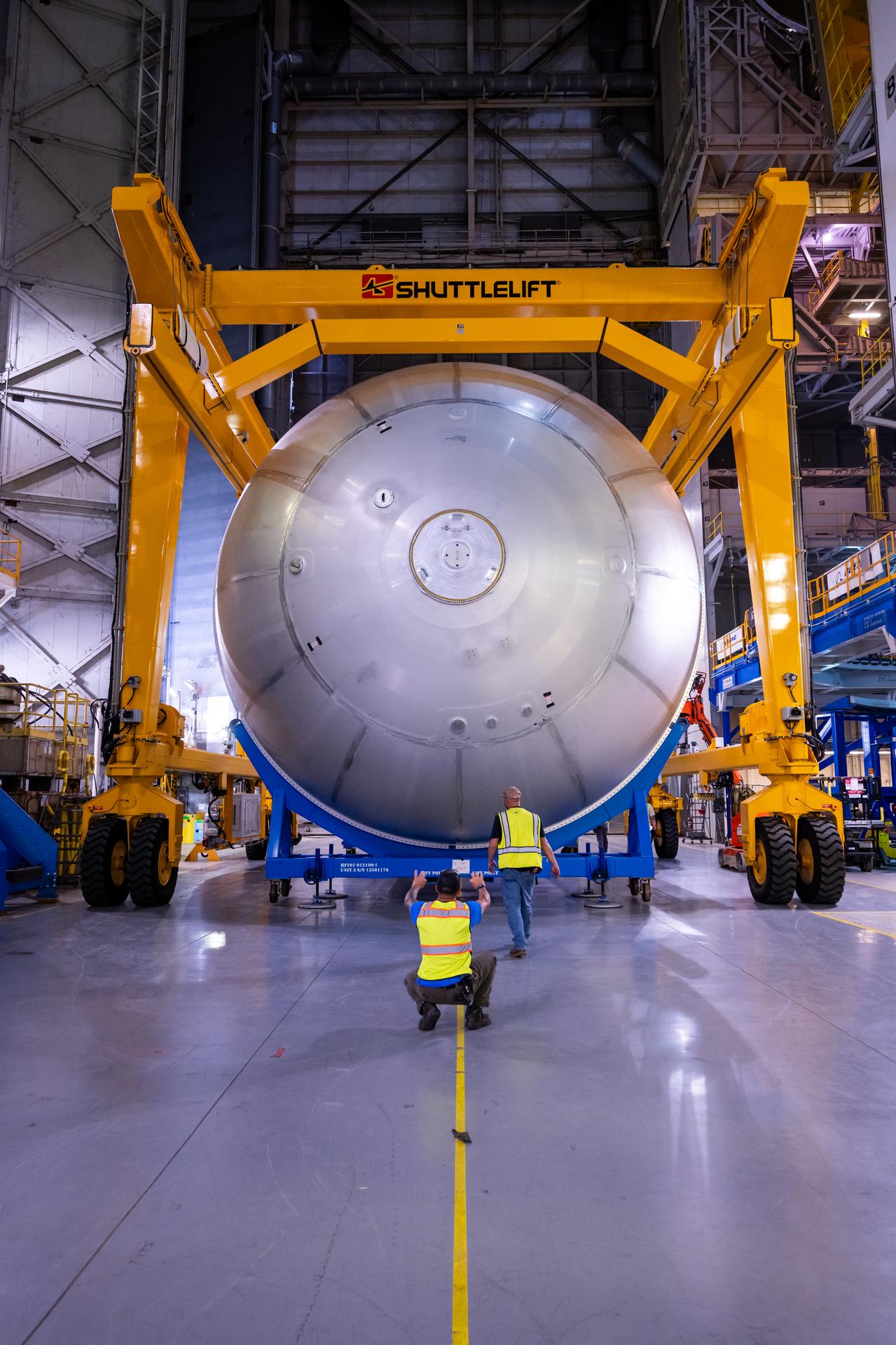 Teams at NASA’s Michoud Assembly Facility in New Orleans move a liquid oxygen tank from the main rocket factory into the adjacent vertical assembly building. The liquid oxygen tank, which will form part of the SLS (Space Launch System) rocket for NASA’s Artemis IV mission to the Moon, is rotated from a horizontal to a vertical configuration and loaded into the high bay’s hydrostatic proof testing cell. This non-destructive evaluation method tests the structural integrity of the tank’s welds by filling the tank with water, simulating the propellant used during launch. The propellant tank will hold more than 196,000 gallons of super-cooled liquid oxygen at launch and is one of five major elements that make up the 212-foot-tall SLS rocket stage. The core stage, along with its four RS-25 engines at its base, produces more than two million pounds of thrust to help launch NASA’s Orion spacecraft, astronauts, and supplies beyond Earth’s orbit and to the lunar surface for Artemis.